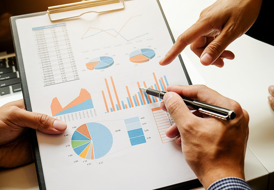 Business concept. Business people discussing the charts and graphs showing the results of their successful teamwork. Selective focus.